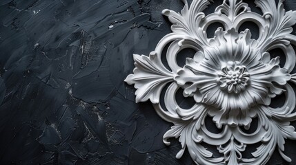 Ornate white floral and scroll relief sculpture on black background.