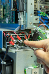 Man's hand repairing an electronic board
