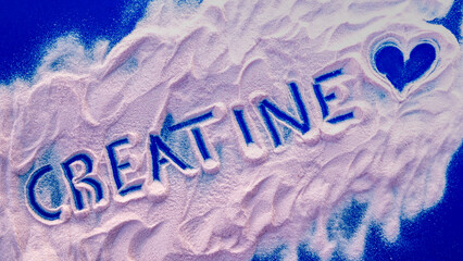 Word creatine written on strawberry creatine powder with a heart. Wellness and gym concept.