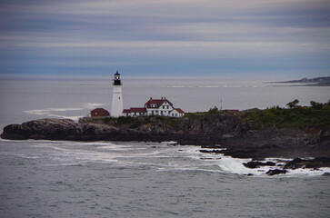 Fototapeta na wymiar New England lighthouse and seascape ocean landscape nature view in Portland, Maine bay with horizon scenic coastal scenery