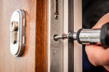 craftsman uninstalls a door lock cylinder
