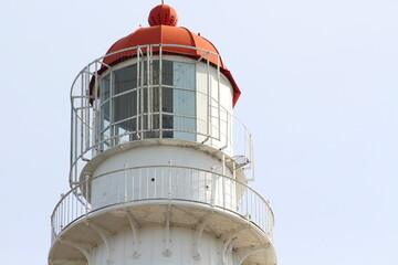 Closeup of a white and red lighthouse