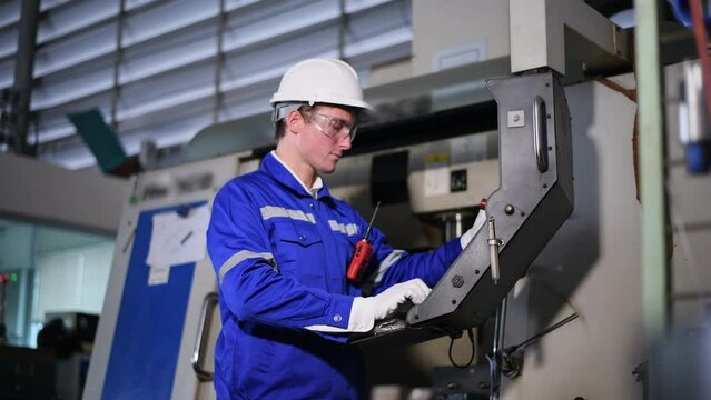 Industry engineer worker wearing safety uniform control operating computer controlled Lathe grinding machine working in industry factory is metal manufacturing industry concept	
