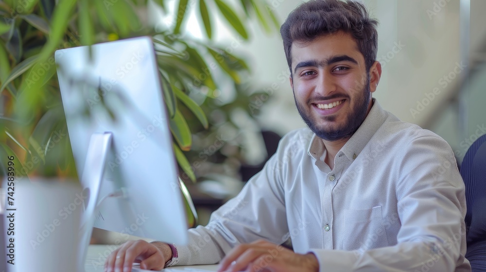 Poster Typical middle eastern businessman working at modern worktable, typing on computer keyboard, sending emails to business partners, doing marketing research, copy space available