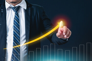 A businessman uses his finger to poke the graph with an arrow pointing upwards, indicating that the business is growing. Business concept that is generating huge profits.