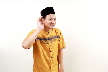 Asian muslim man wearing a typical arab clothes trying to listening a gossip isolated on white background
