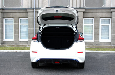 White electric car open trunk. Open empty trunk in white car. Car boot space shot. Modern electric car trunk. Ready for luggage loading.