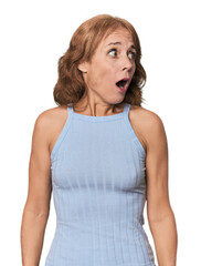 Redhead mid-aged Caucasian woman in studio being shocked because of something she has seen.