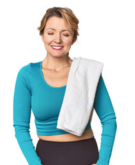 Caucasian woman in sportswear with towel laughs and closes eyes, feels relaxed and happy.