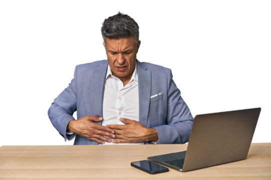 Elegant businessman at desk with laptop having a liver pain, stomach ache. - Powered by Adobe