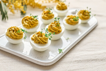 Easter breakfast idea. Stuffed easter eggs mimosa with egg yolk, turmeric, cream cheese and cress salad. Happy Easter traditional dish concept.