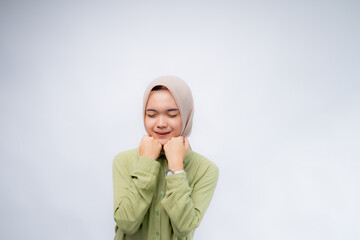 Excited. Portrait of young asian woman wearing hijab clenched his fist on his forehead at Copy Space Advertising Your Text, Standing Isolated Over white Studio Background