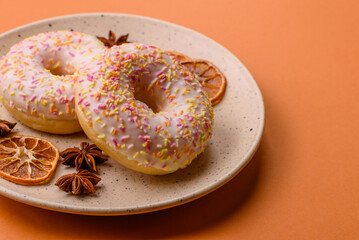 Delicious sweet bright donuts with cream on a plain background