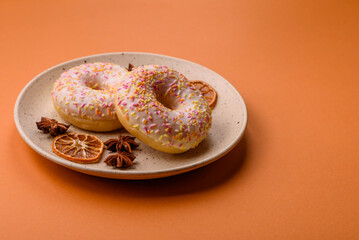 Delicious sweet bright donuts with cream on a plain background