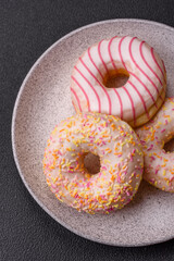 Delicious sweet bright donuts with cream on a plain background
