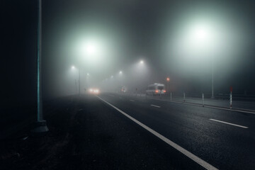 Foggy night road illuminated by street lights