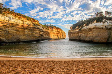 Beach in Loch Ard Gorge surrounded by sandstone cliffs at the Twelve Apostles Marine National Park...
