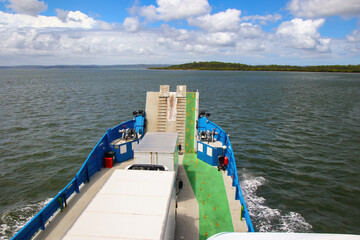 Kingfisher Bay ferry navigating towards Fraser Island (K'gari) with passengers and vehicles in...