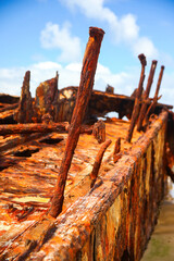 Rusty crumbling piece of the SS Maheno shipwreck half buried in the sand of the 75 mile beach on the east coast of Fraser Island in Queensland, Australia