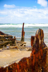 Rusty crumbling piece of the SS Maheno shipwreck half buried in the sand of the 75 mile beach on...