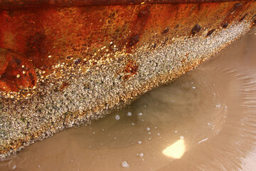 Rusty crumbling piece of the SS Maheno shipwreck half buried in the sand of the 75 mile beach on...