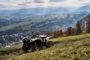 Gray quad bike on the mountain slope overlooking the city below © Victoria Antre