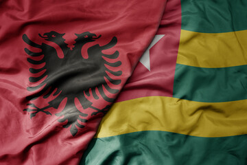 big waving national colorful flag of togo and national flag of albania .