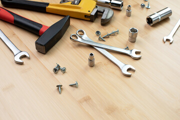A set of working tools, a hammer, a screwdriver, adjustable spanner, sockets for repair on a bamboo, wooden background. Flat lay