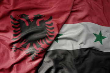 big waving national colorful flag of syria and national flag of albania .