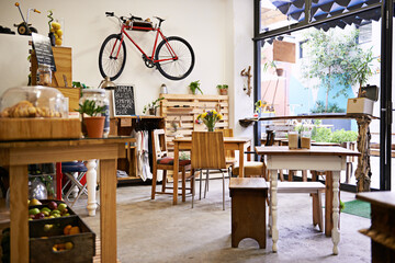Interior, bike on wall of empty coffee shop with tables and chairs for retail, service or...