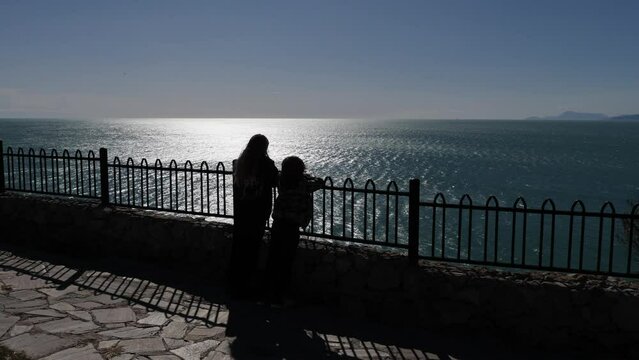 little boy and girl watching sea and talk 