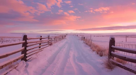 Schilderijen op glas view of a snowy road with fences during a sunset on a cloudy day © DailyLifeImages