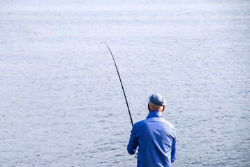 the man is standing with his back and fishing.fishing
