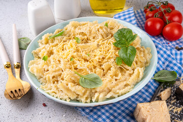 Mafaldine pasta with white sauce, italian bechamel, creamy cheese sauce pasta on white concrete background, with ingredients and spices, copy space