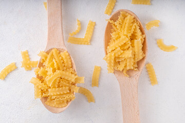 Raw uncooked Mafaldine pasta with ingredients for cooking. Short italian Mafaldine pasta with olive...