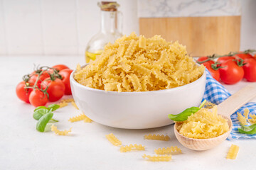 Raw uncooked Mafaldine pasta with ingredients for cooking. Short italian Mafaldine pasta with olive...