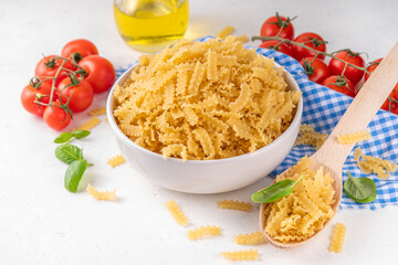 Raw uncooked Mafaldine pasta with ingredients for cooking. Short italian Mafaldine pasta with olive...