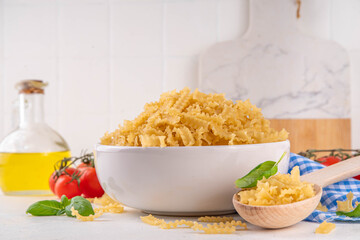Raw uncooked Mafaldine pasta with ingredients for cooking. Short italian Mafaldine pasta with olive...