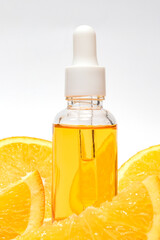 A close-up of a Vitamin C serum bottle with a droplet, surrounded by fresh, vibrant orange slices. mockup