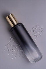 Luxury bottle of toner on gray background. Skincare Product. Toner with peptides. Empty packaging mock up bottle
