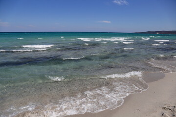 Fototapeta na wymiar Turquoise sea water and waves in La Cinta Beach in San Teodoro, Sardinia, Italy