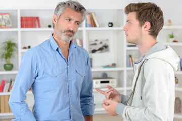 Father listening to son, looking unconvinced - obrazy, fototapety, plakaty