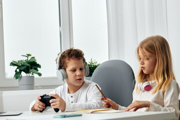 Fototapeta premium Young siblings enjoying a fun and educational moment together, using technology as they sit indoors The brother and sister, with happy and curious expressions, are using a smartphone to connect to the