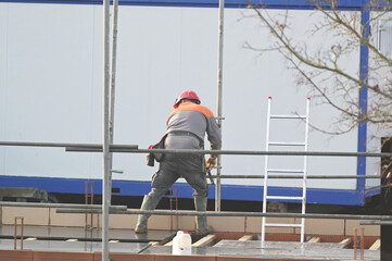 ouvrier montant un échaffaudage sur un chantier de construction - 742766926