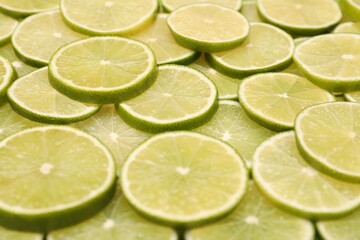 Many juicy lime slices as background, above view