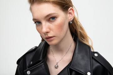 Close up portrait of a beautiful elegant woman with freckles with stylish jewelry on a white...