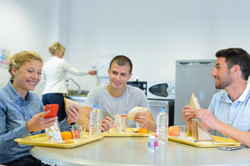 group of people having lunch lady laughing at smartphone