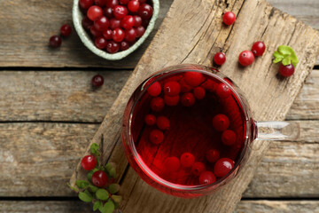 Delicious cranberry tea and berries on wooden table, flat lay