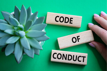 Code of conduct symbol. Wooden blocks with words Code of conduct. Beautiful green background with...