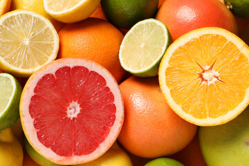 Different fresh citrus fruits as background, top view
